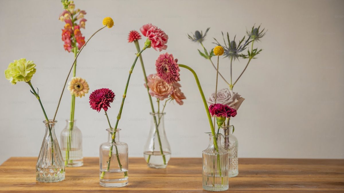 a wooden table topped with vases filled with flowers