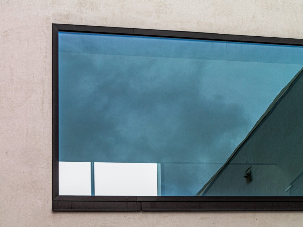 black framed glass window on gray concrete wall